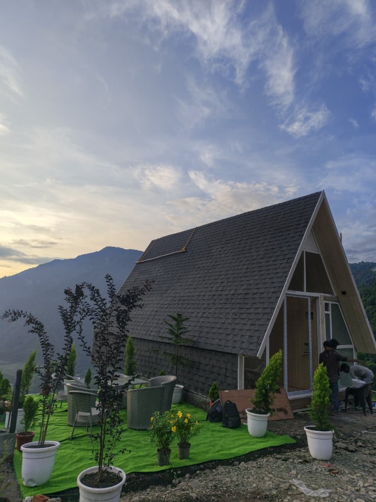 Real A-frame cottage actual site photograph with mountain views and outdoor garden seating